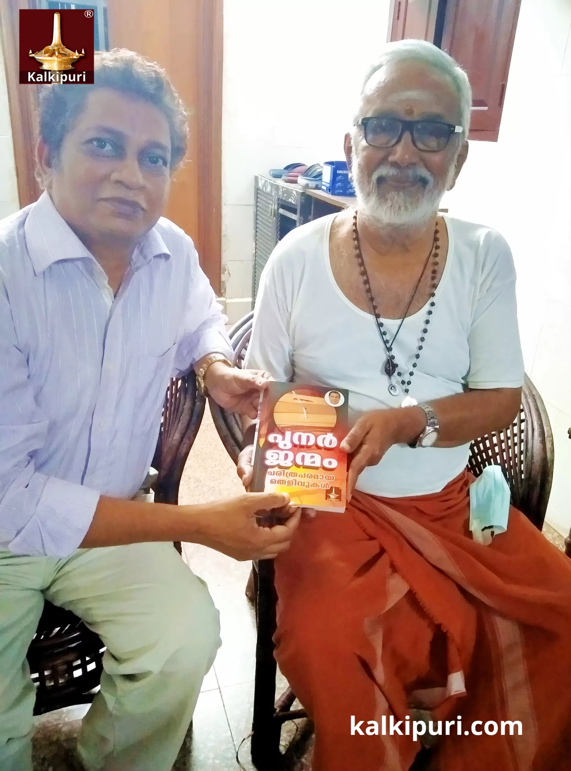Mukundaraj handed over the Book (Punarjanmam Charithraparamaaya Thelivukal by Kalki) to Chandrahasan